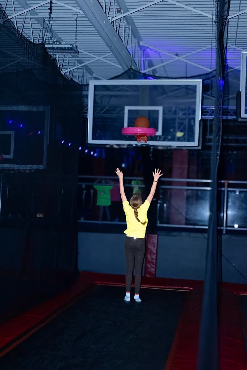 Kid jumping toward the Aero Hoops basketball attraction at AeroSports