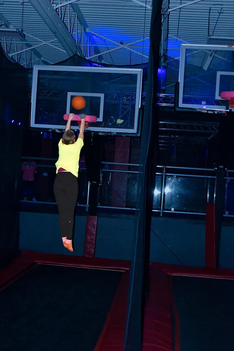 Kid jumping toward the Aero Hoops basketball attraction at AeroSports