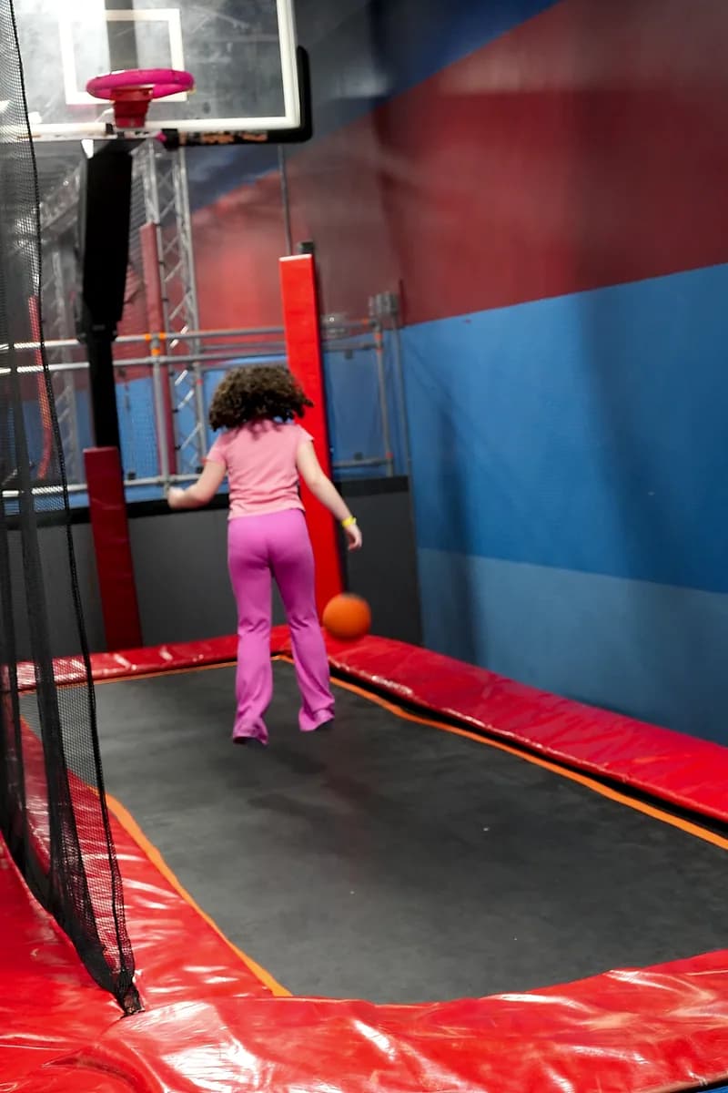 Kid jumping toward the Aero Hoops basketball attraction at AeroSports